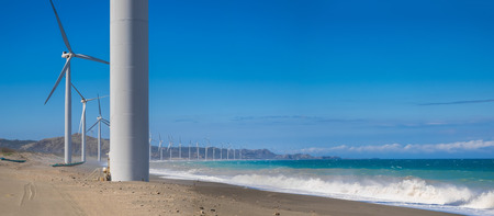 Wind turbine power generators silhouettes at ocean coastline. Alternative renewable energy production in Philippinesの写真素材