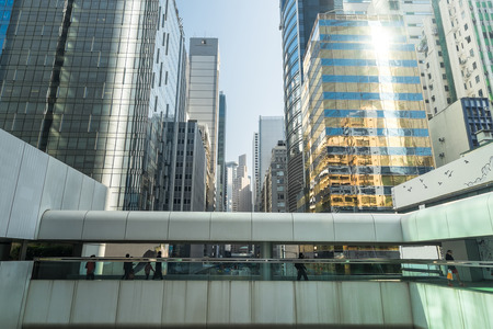 Abstract futuristic cityscape view with modern skyscrapers and people walking on bridge. Hong Kongのeditorial素材
