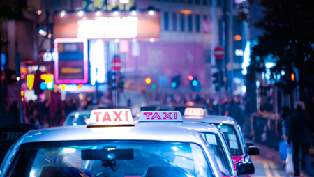 Abstract cityscape blurred background with taxi car at night city street, Hong Kongの写真素材