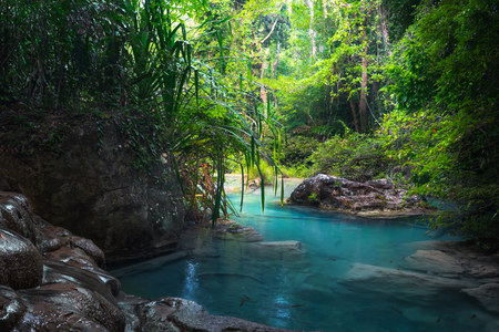 Jangle landscape with flowing turquoise water of Erawan cascade waterfall at deep tropical rain forest. National Park Kanchanaburi, Thailandの写真素材