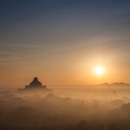 Amazing misty sunrise colors and silhouette of ancient Dhammayan Gyi Pagoda. Architecture of old Buddhist Temples at Bagan Kingdom, Myanmar (Burma). Travel landscapes and destinationsの写真素材