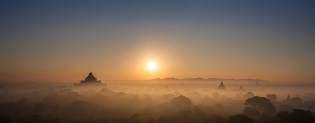 Amazing misty sunrise colors and silhouette of ancient Dhammayan Gyi Pagoda. Architecture of old Buddhist Temples at Bagan Kingdom, Myanmar (Burma). Travel landscapes and destinationsの写真素材