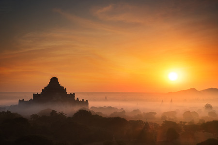 Amazing misty sunrise colors and silhouette of ancient Dhammayan Gyi Pagoda. Architecture of old Buddhist Temples at Bagan Kingdom, Myanmar (Burma). Travel landscapes and destinationsの写真素材