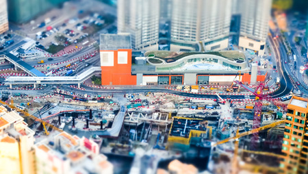 Tilt shift blur effect. Amazing aerial cityscape view with crane working at building construction. Hong Kong. Abstract futuristic cityscape with modern skyscrapersの写真素材