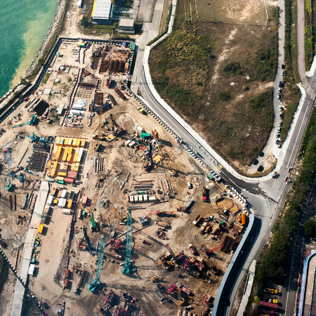 Aerial cityscape view with crane working at building construction near the harbor. Hong Kong....