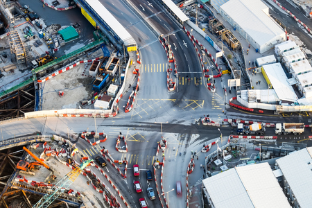 Aerial view of busy crossroad with moving cars in construction area of modern developing city. Hong Kong abstract futuristic cityscapeの写真素材