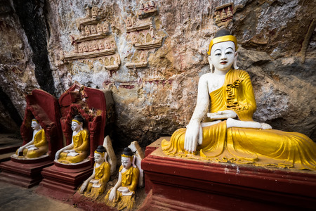 Amazing view of lot Buddhas statues and religious carving on limestone rock in sacred Kaw Goon cave....