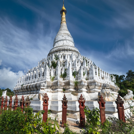 White Pagoda at Inwa ancient city with lions guardian statues. Amazing architecture of old Buddhist Temples. Myanmar (Burma) travel landscapes and destinationsの写真素材