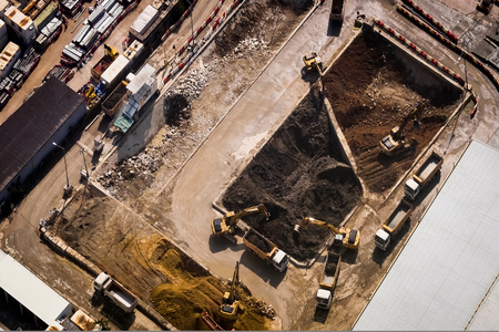 Aerial view excavators and tipper trucks working at construction. Hong Kongの写真素材