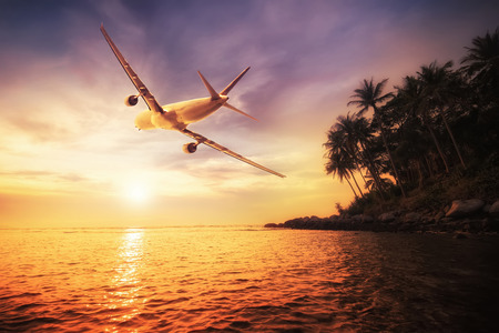 Airplane flying over amazing tropical sunset landscape. Thailand travel destinationsの写真素材