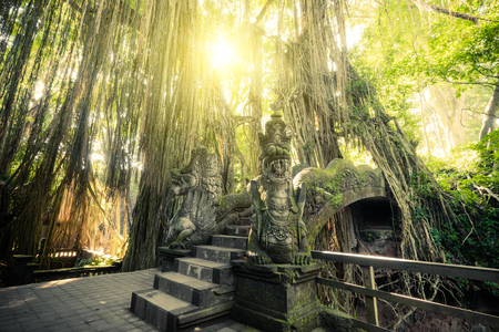 Surreal sunrise colors of fantasy Monkey Forest with Barong Lion bridge and Hindu Temple. Bali,...