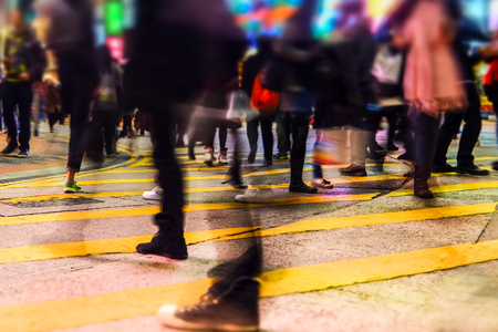 Blurred image of people moving in crowded night city street.. Hong Kongの写真素材