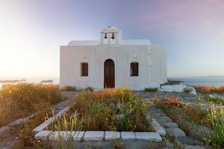 Sunset at Plaka, chief town of Milos island on Kastro hill. Top view in beautiful evening, Greece. Old fortress and ancient church. Peaceful water of sea and mountains on backgroundの写真素材