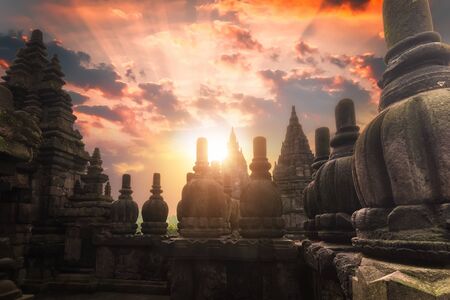 Rising sun shining behind Candi Prambanan or Rara Jonggrang Hindu temple located near Yogyakarta,...