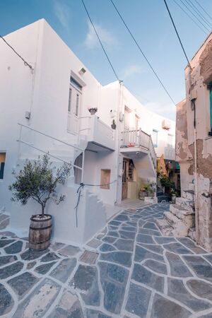 Amazing narrow streets of popular destination on Paros island. Greece. Traditional architecture and colors of mediterranean city. Blue doors, white buildings and bougainvillea flowers in paradiseの写真素材