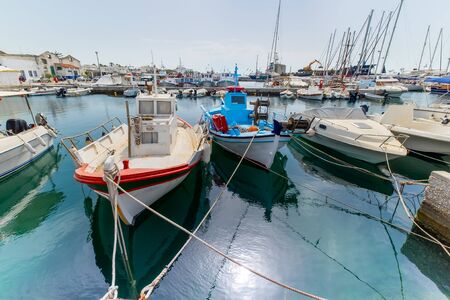 Panoramic view of Paros island popular tourist attraction, Naousa town.  Promenade zone along port with restaurants and shops. Harbor of Aegean Sea, boats and yachts in quay at calm morning. Greeceの写真素材