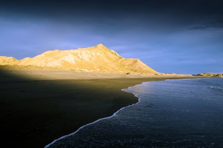 Sunset on deserted New Zealand beachの写真素材