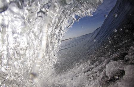 Blue surfing wave view from inside the tubeの写真素材