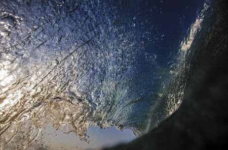 Blue surfing wave view from inside the tubeの写真素材