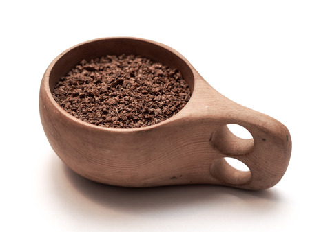 Soybean meal in a wooden mug on a white tableの写真素材