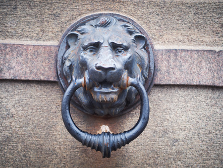 A metal relief of a lion with a ring in his mouth
