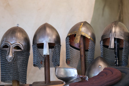 Four different medieval style helmets on wooden standsの写真素材
