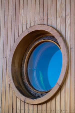 A porthole on a wooden wall