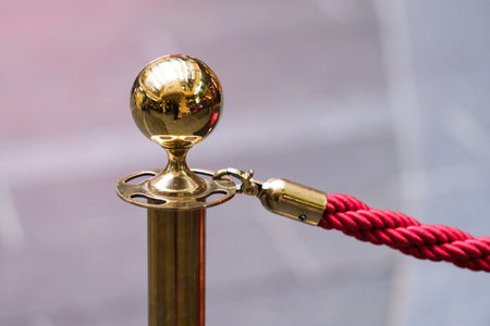 Close up of a golden pole rope barrier