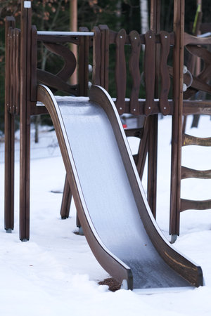 Wooden slide on a playground  in winterの写真素材