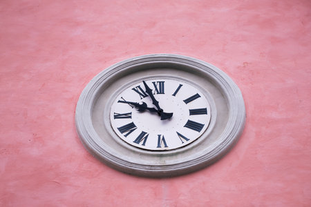 Clock on a light red stone wall