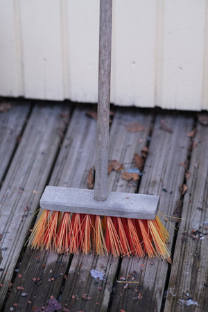 A broom with orange bristlesの写真素材