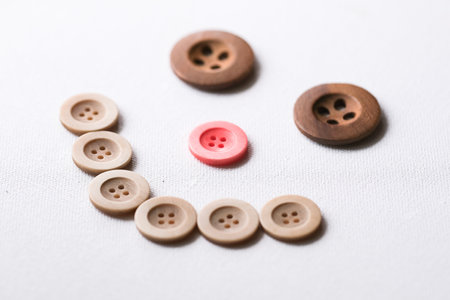 Smiling button face on a white tableの写真素材