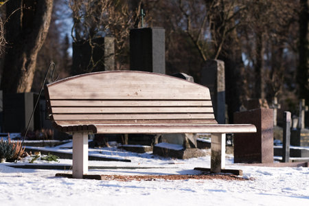 Park bench on a cemetary in winterの写真素材