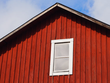 Red wooden house with a white windowの写真素材
