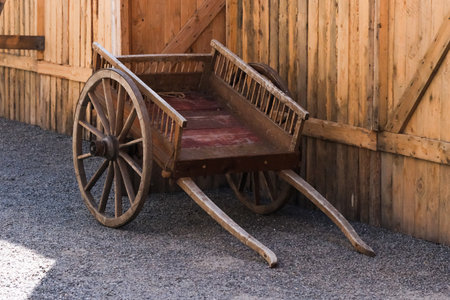 An old wooden handcart at a wall