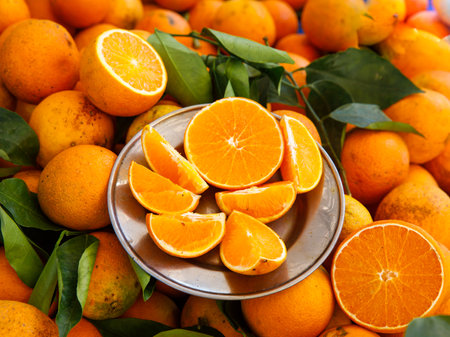 Cut and whole fresh ripe organic oranges with green leaves as background, top view. local farmer marketの写真素材