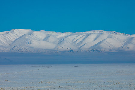 View from Chui steppe to South Chui ridge in winter day. Russia South Of Western Siberia, Altai Mountains. Desert mountains covered with snow near village of Kosh-Agachの写真素材