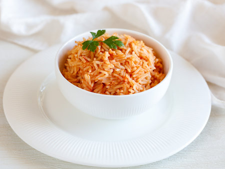 Tomato onion rice, Tamatar Biryani, jollof in white bowl on a white wooden table, horizontalの写真素材