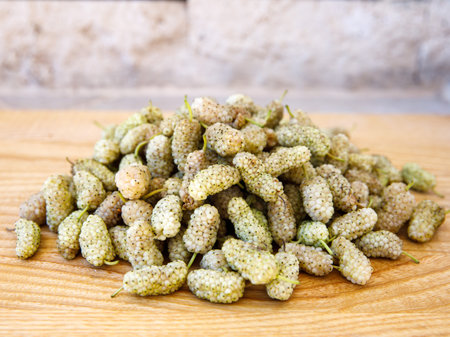 Fresh white mulberry on wooden background. (Morus alba) Side view close-up. Summer organic fruits. Mulberry backgroundの写真素材