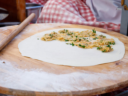 Process of making a traditional Turkish dough is called Gozleme, selective focus. It is made of flat bread stuffed with meat or cheese and baked on sheet iron or pan. Baked in a pan called a saj.の写真素材