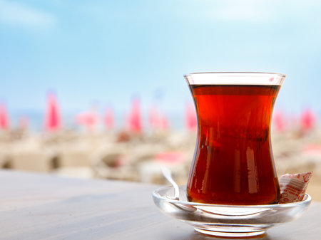 Turkish tea in a traditional glass (tulip) Bardak against the background of beach. Holiday in Turkey, travel resortの写真素材