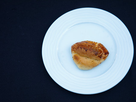Traditional turkish bun pastry product , tasty pogaca with cheese filling on white plate, top viewの写真素材