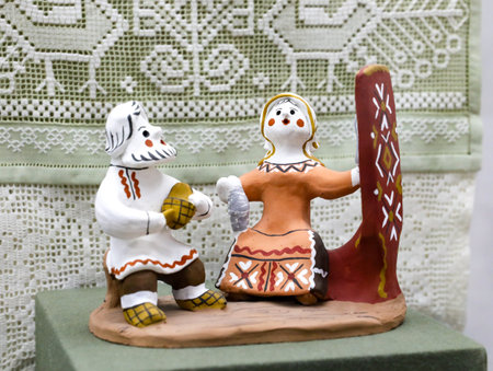 Kargopolskaya toy, man with beard with a bast shoe and a woman with a spinning wheel. Traditional Kargopol clay toy (Russian North). folk art. Souvenir from Russia.の写真素材