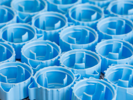 Small blue plastic bottle caps background. Recycling collection and production processing plastic bottle caps. side view, close upの写真素材