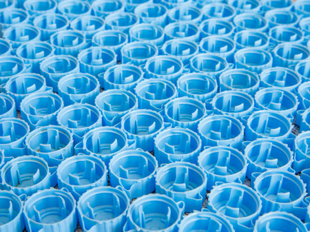 Small blue plastic bottle caps background. Recycling collection and production processing plastic bottle caps. side view, close upの写真素材
