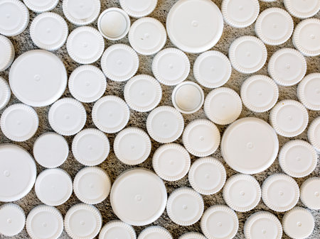 Different size white plastic bottle caps background. Recycling collection and production processing plastic bottle caps. top view, copy spaceの写真素材