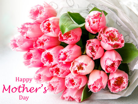 Inscription Happy mothers day with bunch of light gentle pink Fringed Mascotte tulip, bouquet flowers. Spring tulips on white wooden background greeting card. side view. selective focus. close upの写真素材