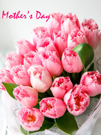 Inscription mothers day with bunch of light gentle pink Fringed Mascotte tulip, bouquet flowers. Spring tulips on white wooden background card. side view. selective focus. Close up verticalの写真素材