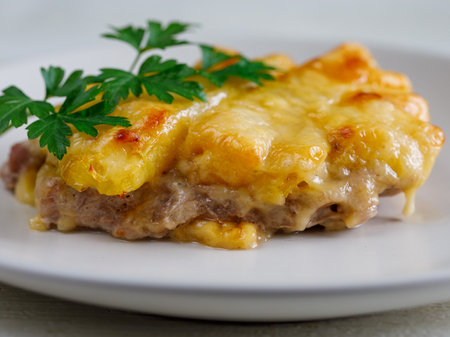 Baked Pork Steak with Pineapple grated with cheese on white plate close up.の写真素材