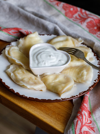 Ukrainian, Russian or Polish dish: varenyky, vareniki, pierogi, pyrohy. Dumplings, filled with cottage cheese (farmer cheese) and served with sour cream. top, overhead, above view, verticalの写真素材